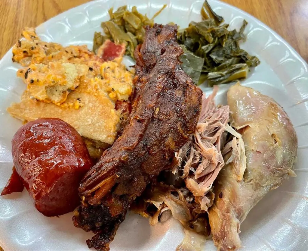 Ribs, chicken, and sausage on plate with two sides