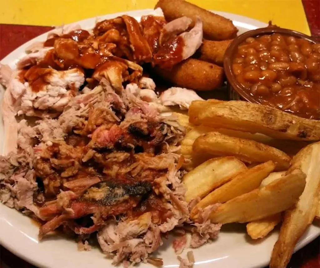 BBQ, fries, baked beans, hush puppies on plate