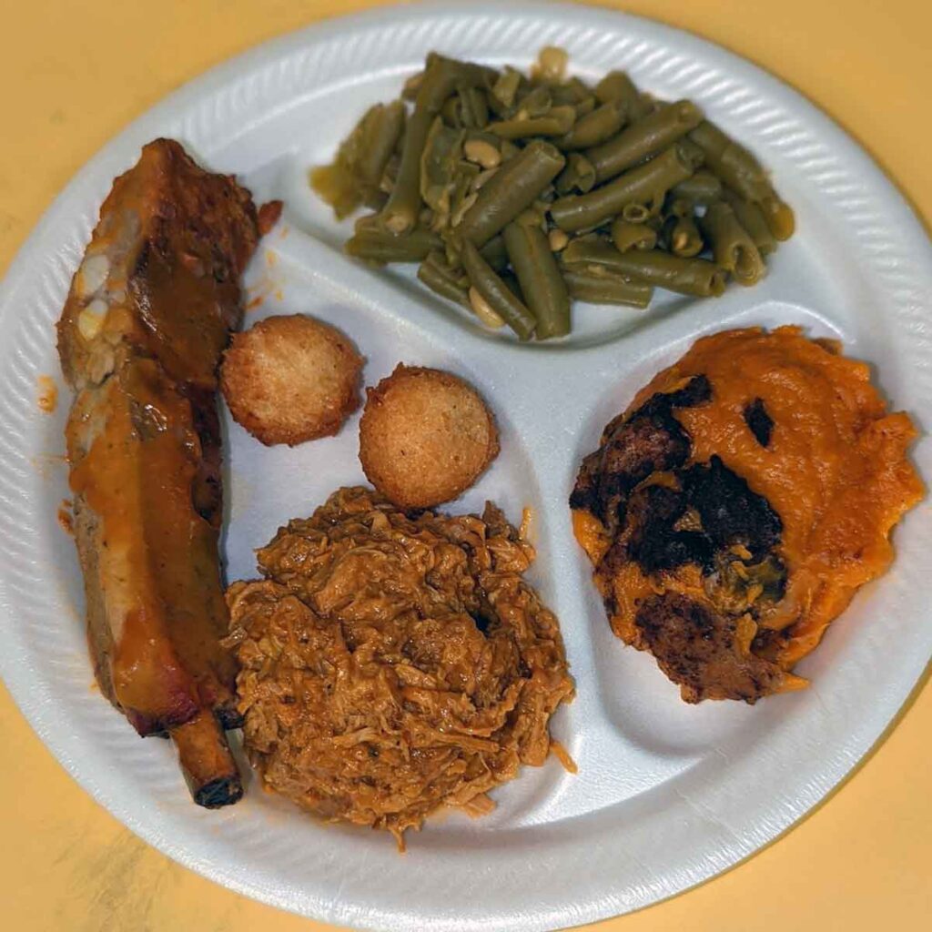 BBQ, rib, green beans, sweet potatoes, and hushpuppies on a plate