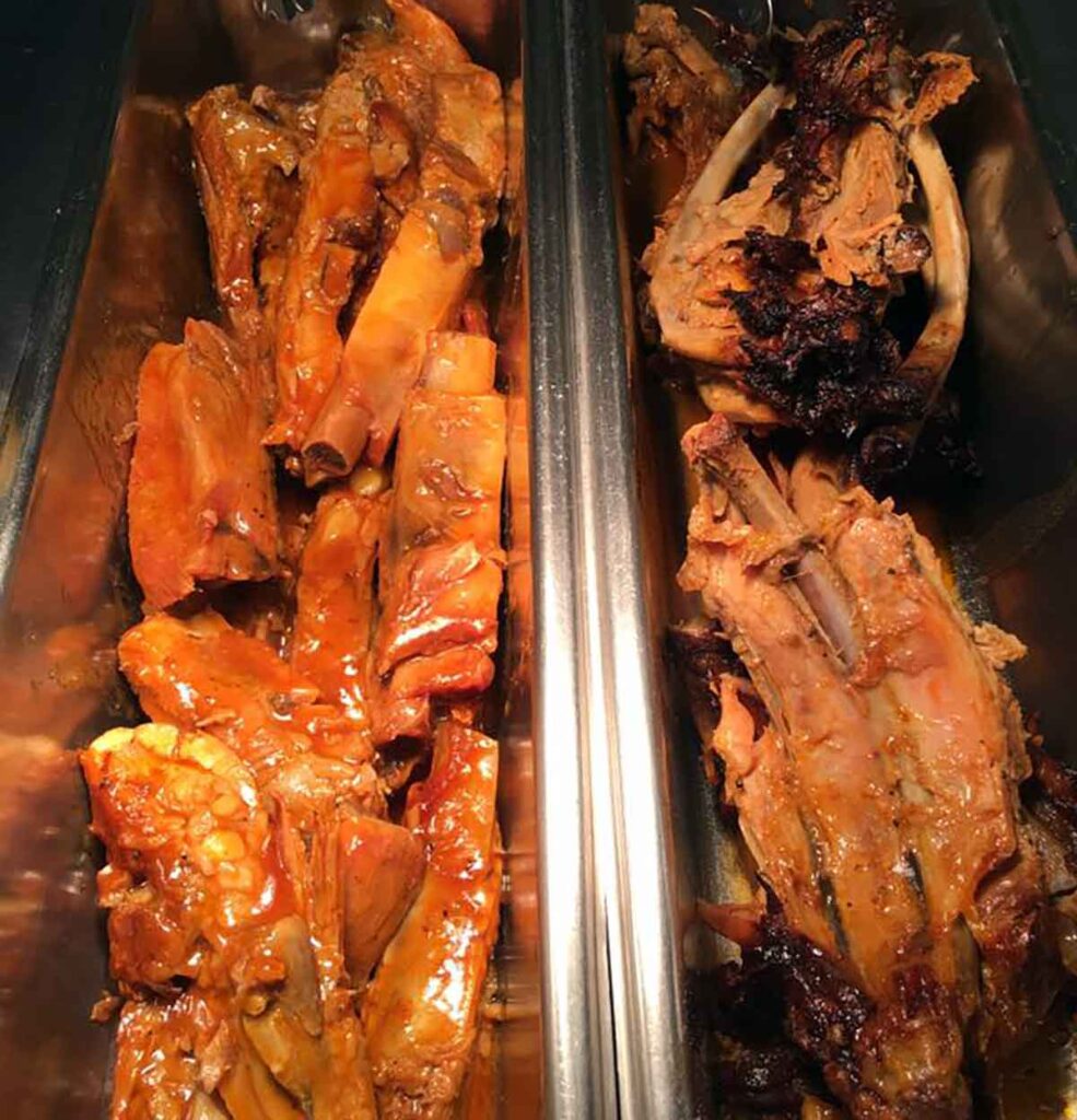 Two trays of ribs on buffet.