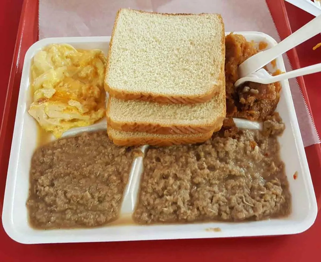 Styrofoam stray filled with beef hash, sliced white bread, and two sides