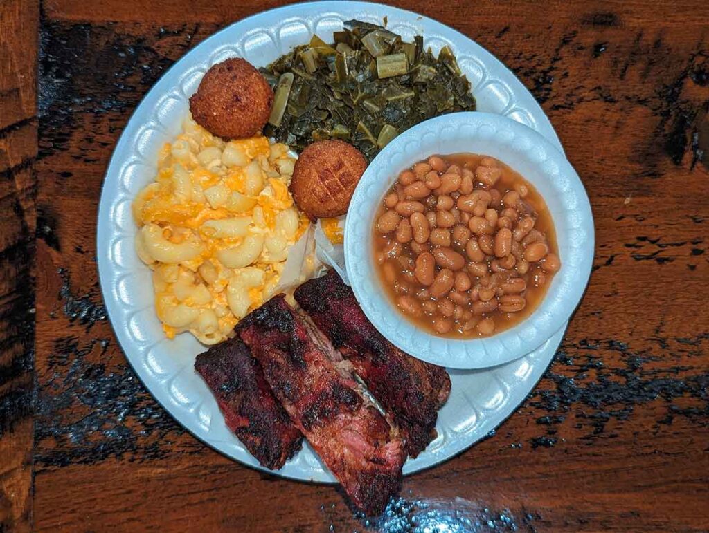 Rib plate with baked beans, collards, hush puppies, and Mac and cheese.
