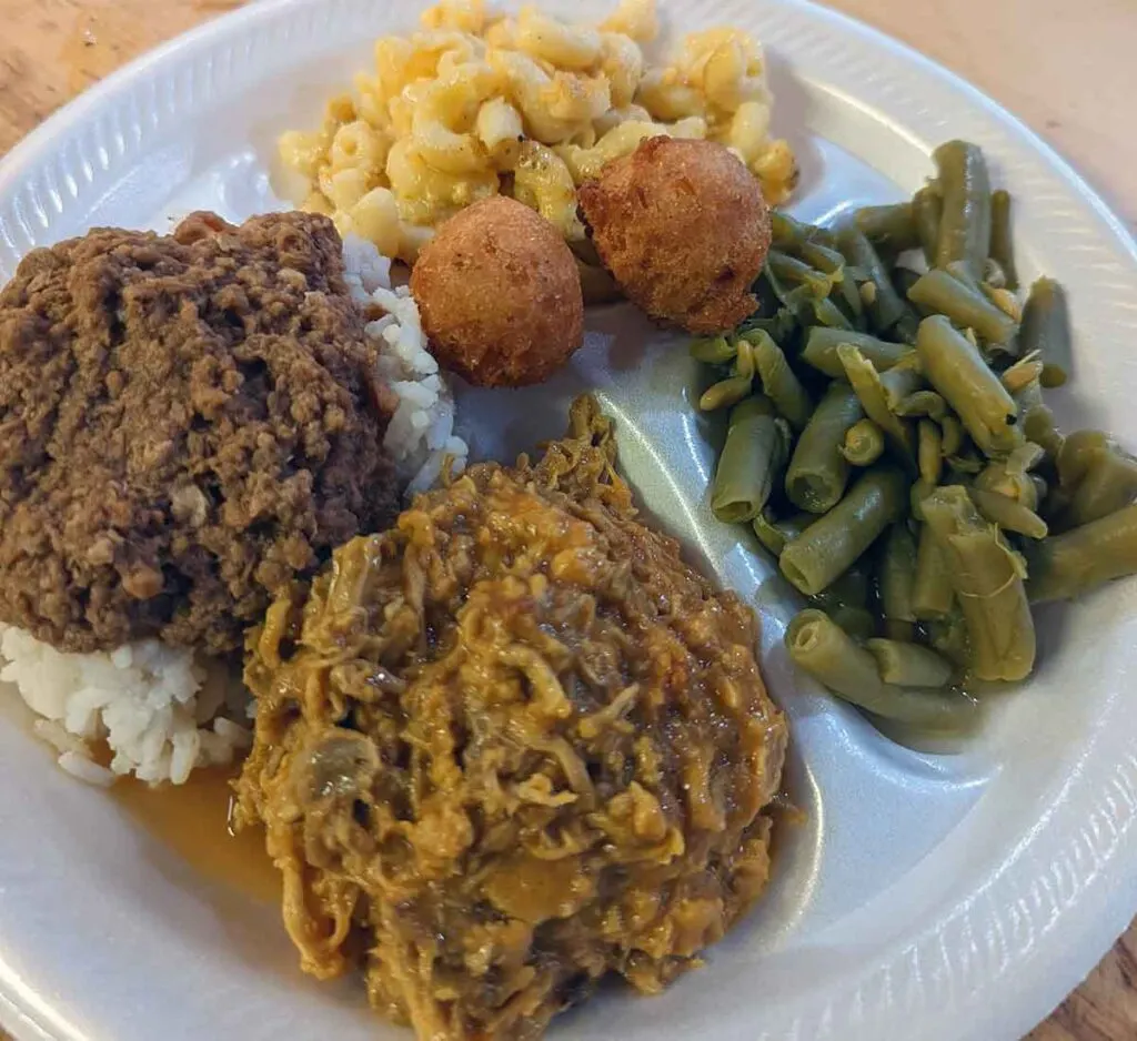 BBQ, hash, Mac n cheese, green beans and hushpuppies on a styrofoam plate