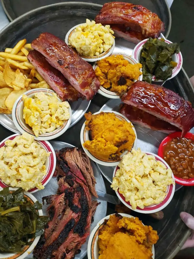 Lots of different smoked meats and sides filling photo