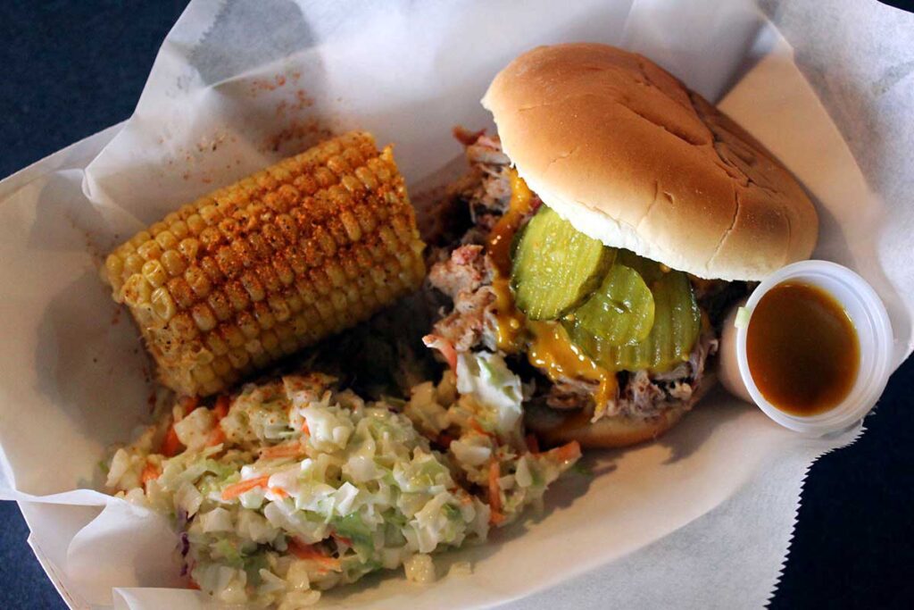 BBQ sandwich tray with seasoned corn and slaw.