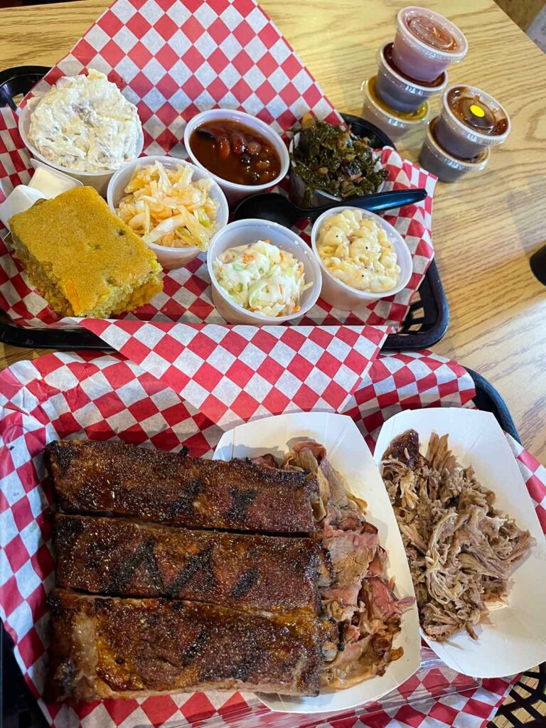Two trays full of many of the meat and sides offerings at Bullies BBQ.