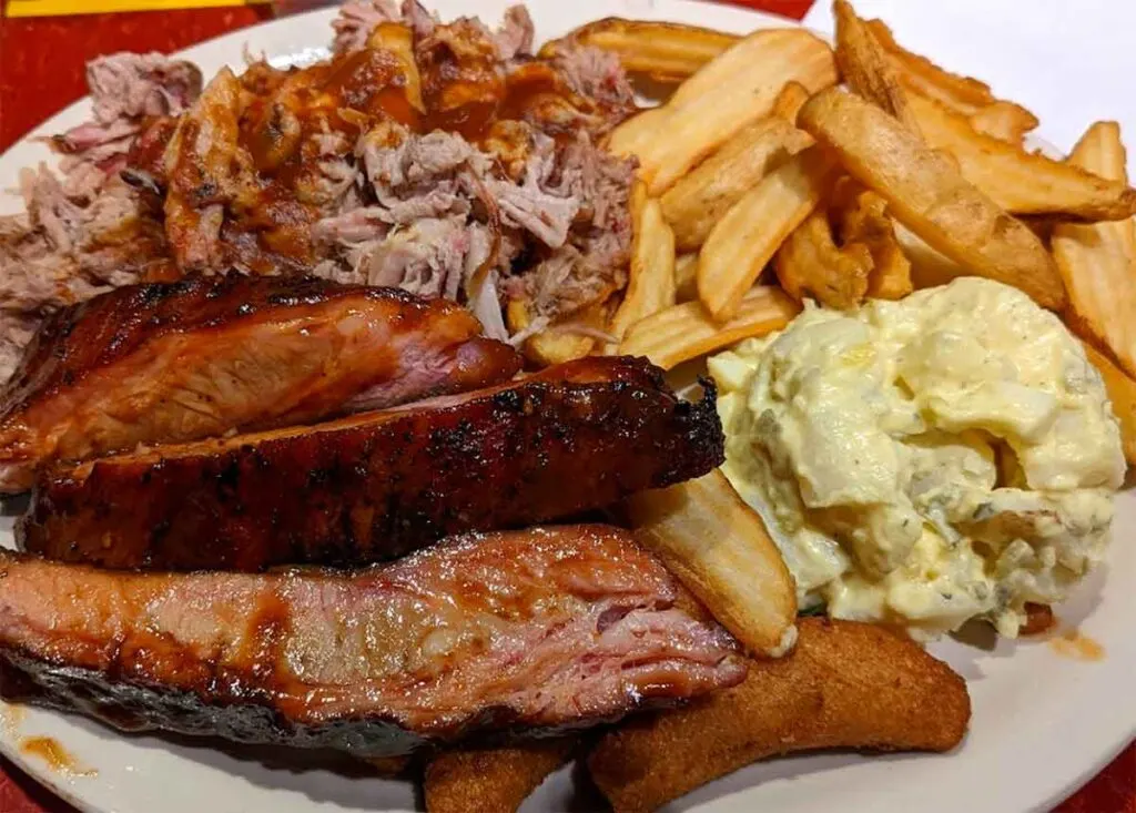 Ribs, potato salad, fries and BBQ on plate