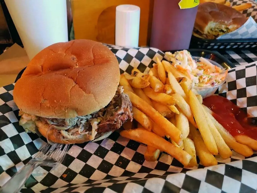 BBQ sandwich with slaw, fries, and ketchup.