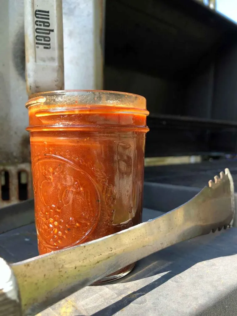 Gates and Sons BBQ Sauce in Mason jar on side of grill
