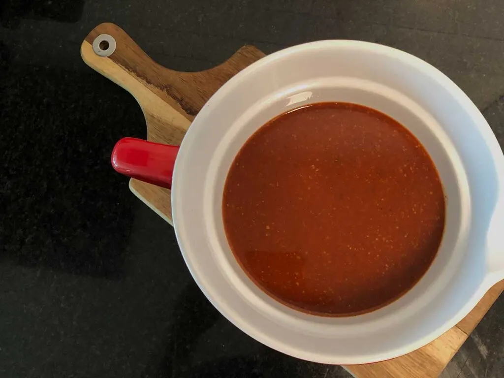 Homemade Gates BBQ Sauce recipe in bowl on cutting board.