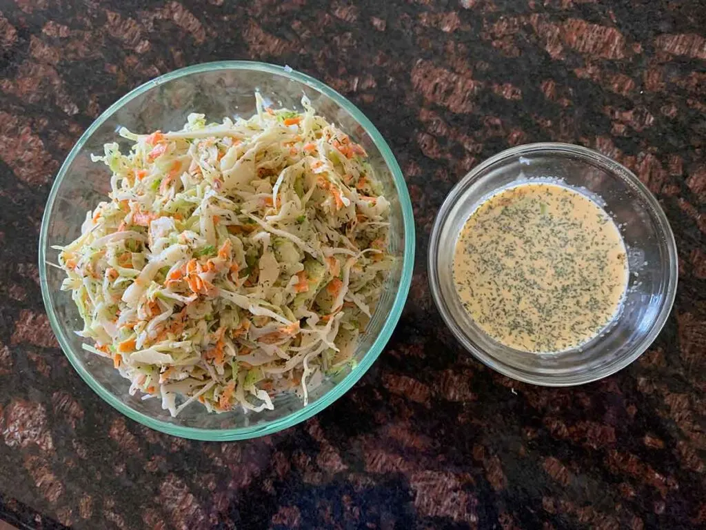 Bowl of Memphis Style Slaw beside smaller bowl of coleslaw sauce.