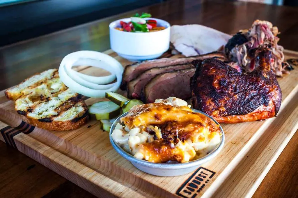 Three meat platter with brisket, chicken, pulled pork and sides.