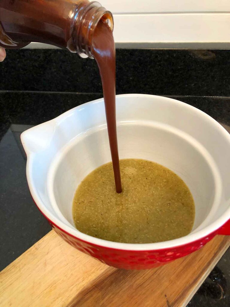 Pouring Sticky Fingers BBQ sauce into Mojo sauce.