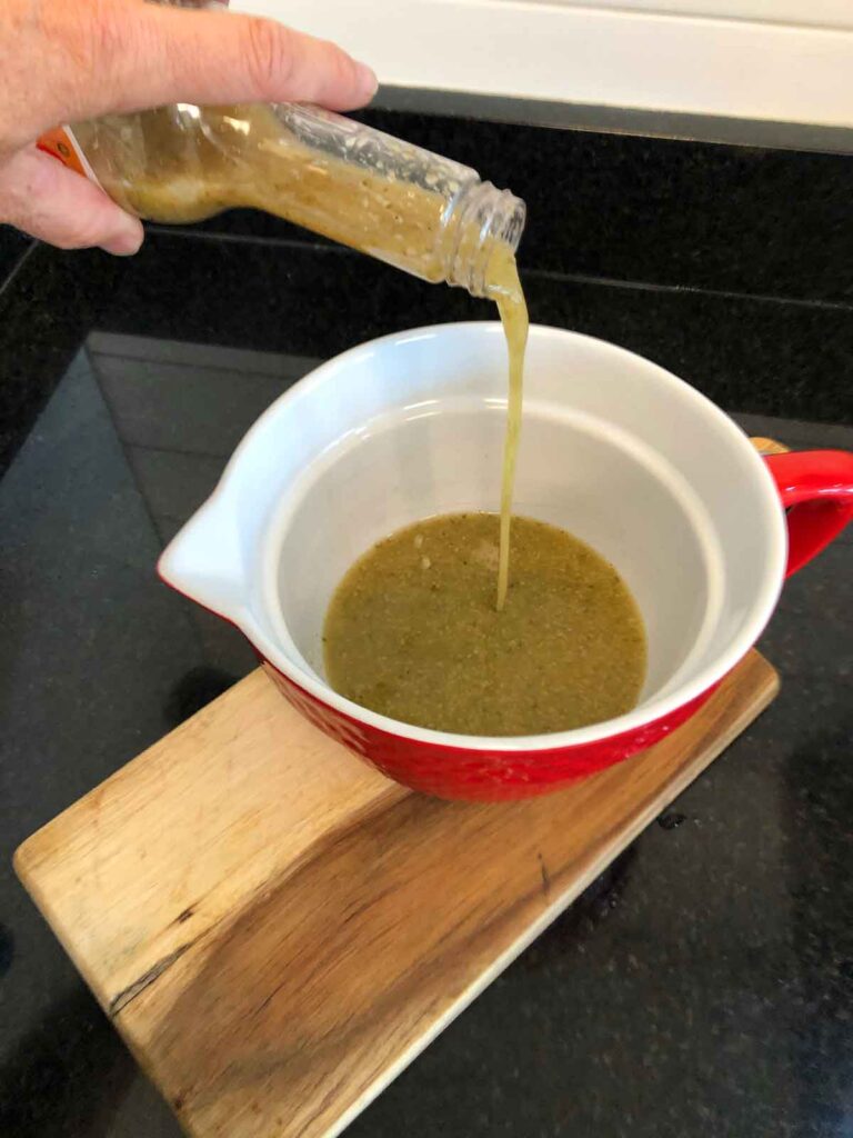 Pouring Badia Mojo marinade into bowl to make brisket mojo sauce