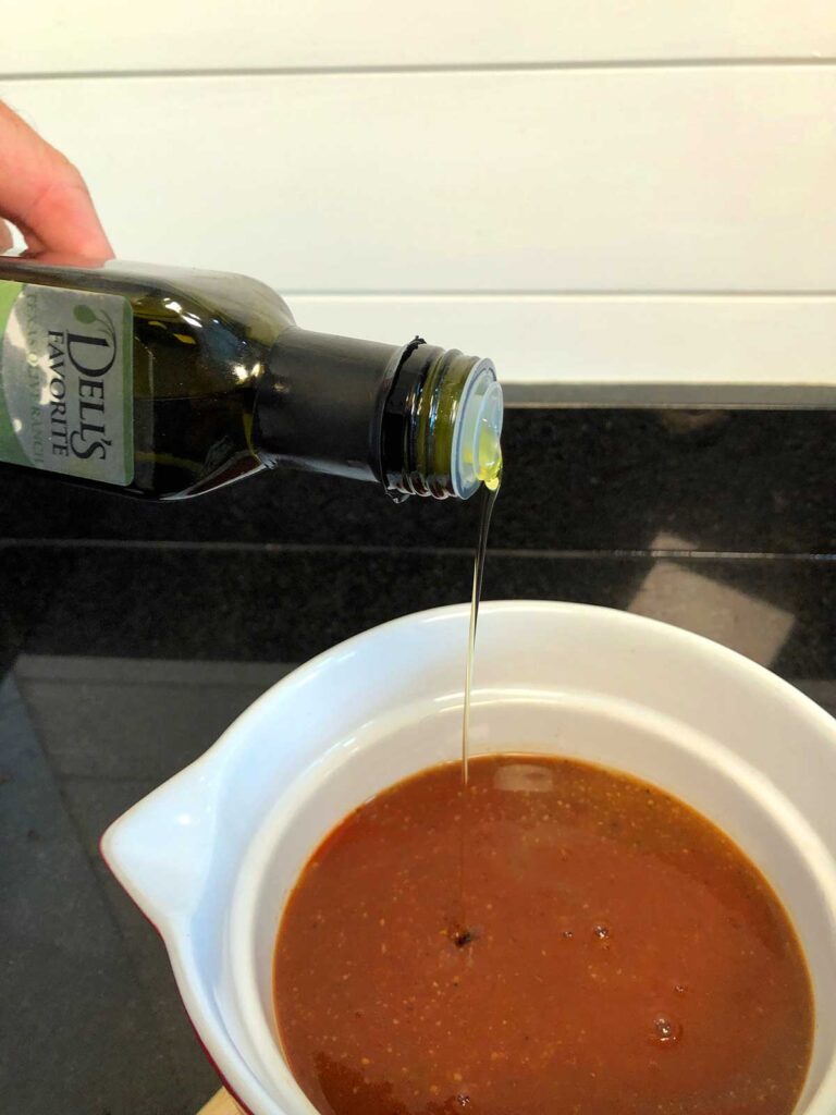 Pouring olive oil into Mojo sauce.