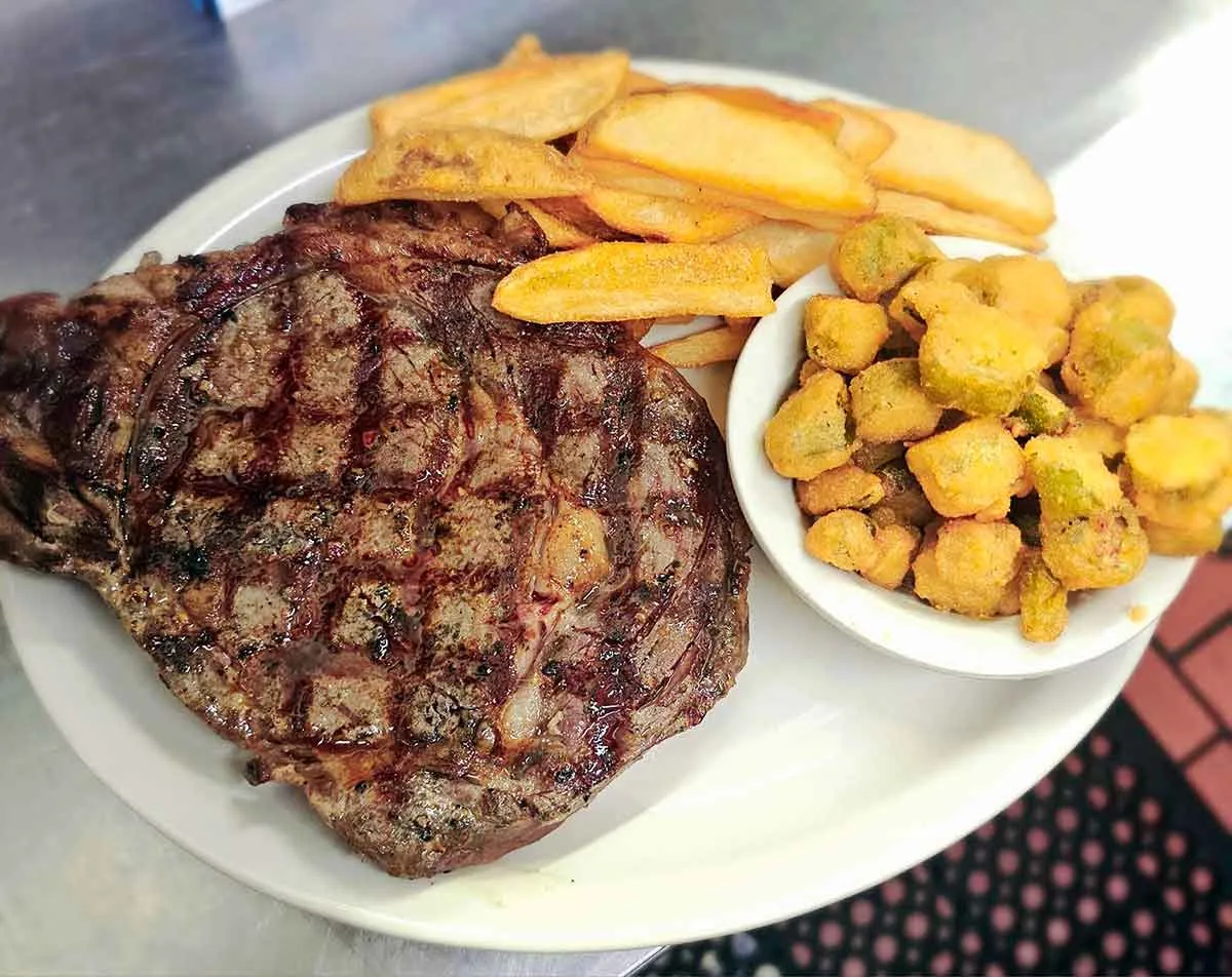 Ribeye steak with fries and fried okra.