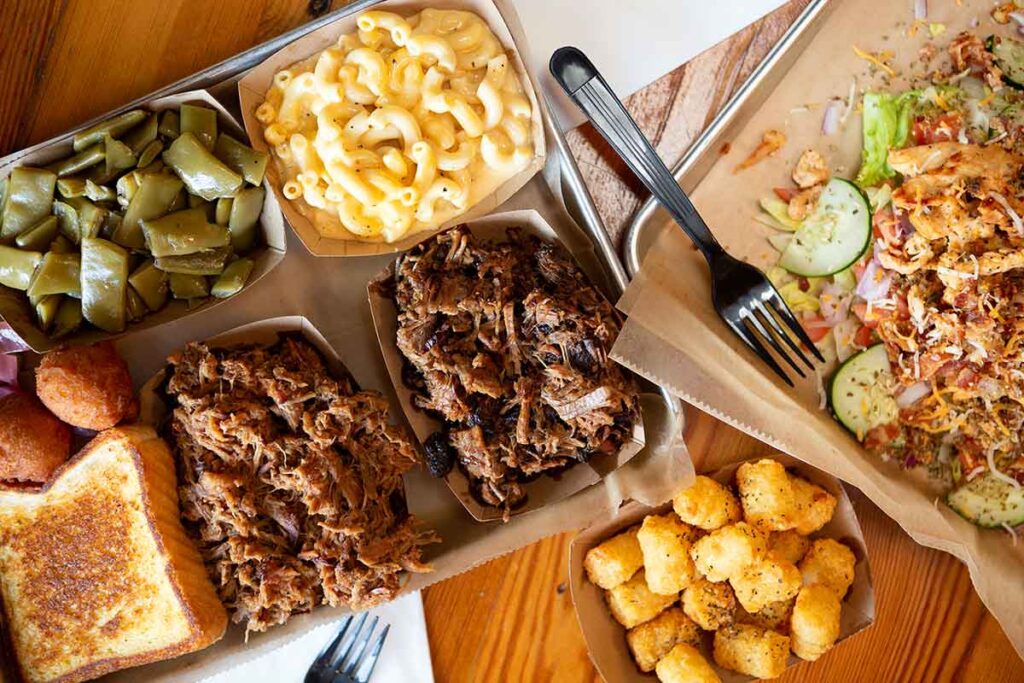 BBQ trays with meat, sides, and salad.