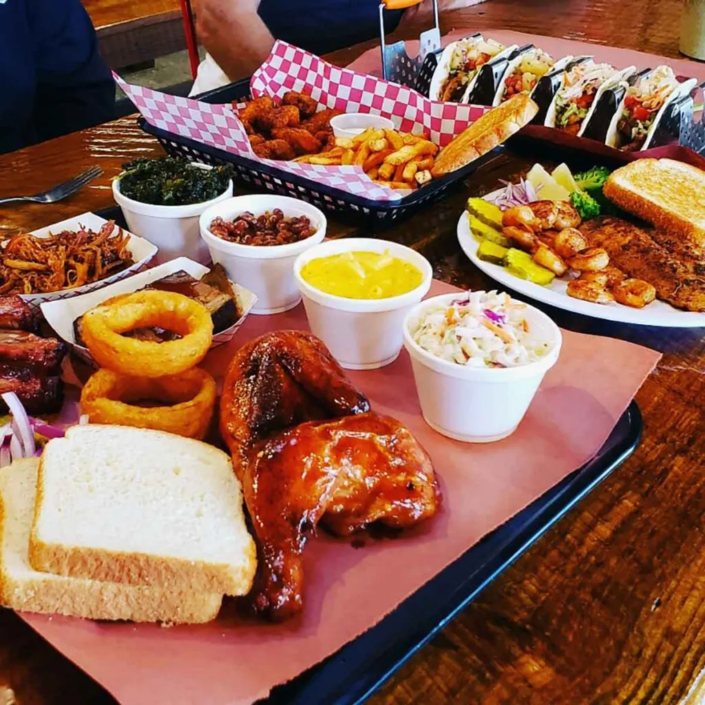 Eye-level view of meats and sides on a table at Piggyback's BBQ.