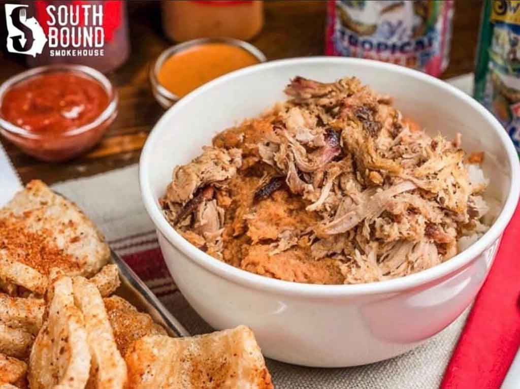 Barbecue and hash over rice in a bowl with a side of pork rinds