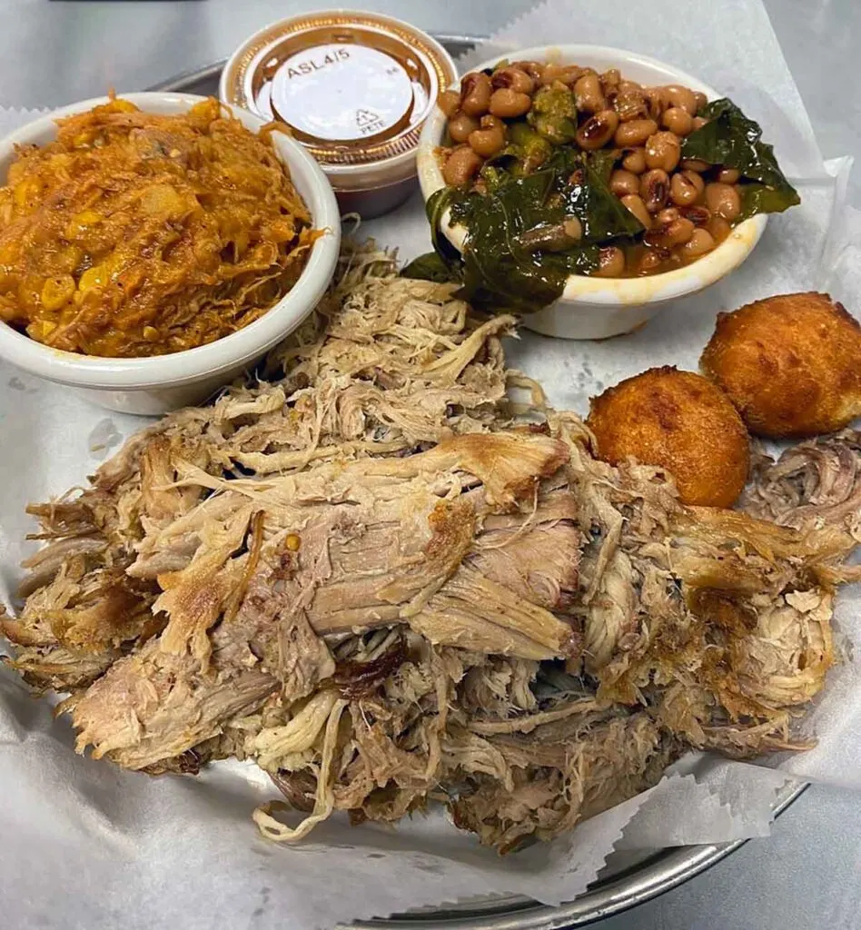 Plate filled with pulled pork and sides.