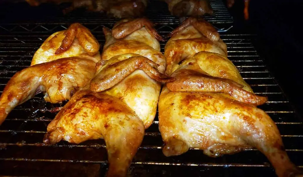 Chicken halves on the pit.