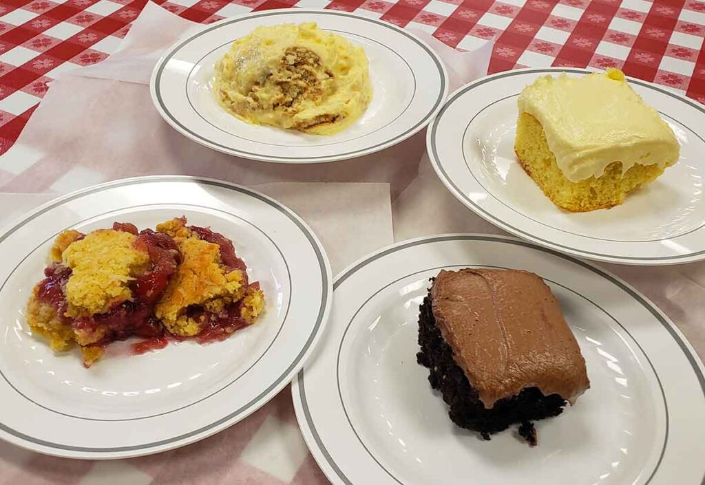 Four plates with a serving of dessert on each.