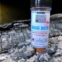 Bottle of Rodney Scott's Rib Rub in ashes of fire