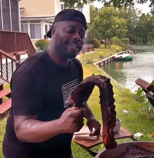 Rodney Scott holding spareribs that bend because so tender