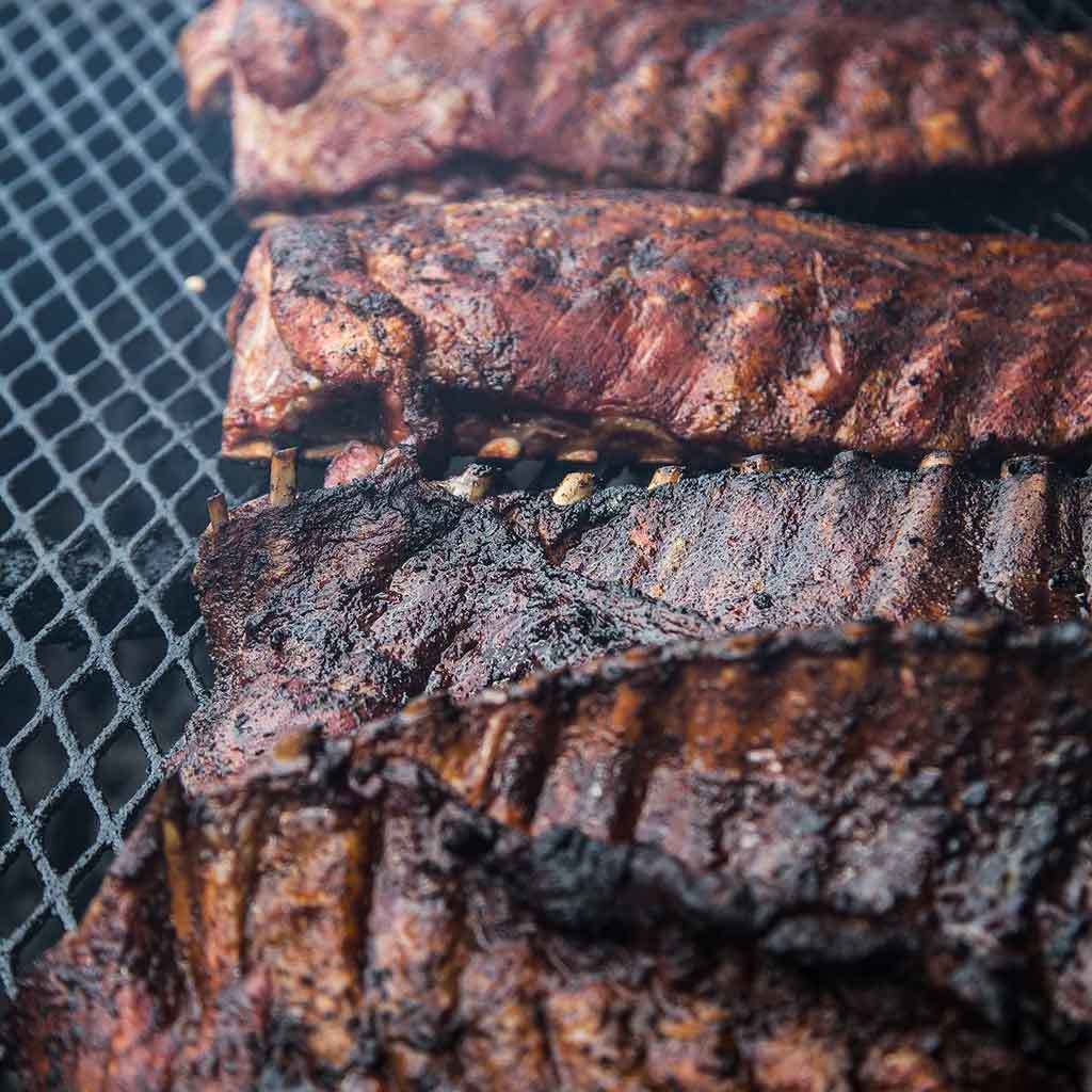 Several racks of spareribs on the grill showing the Himalayan effect