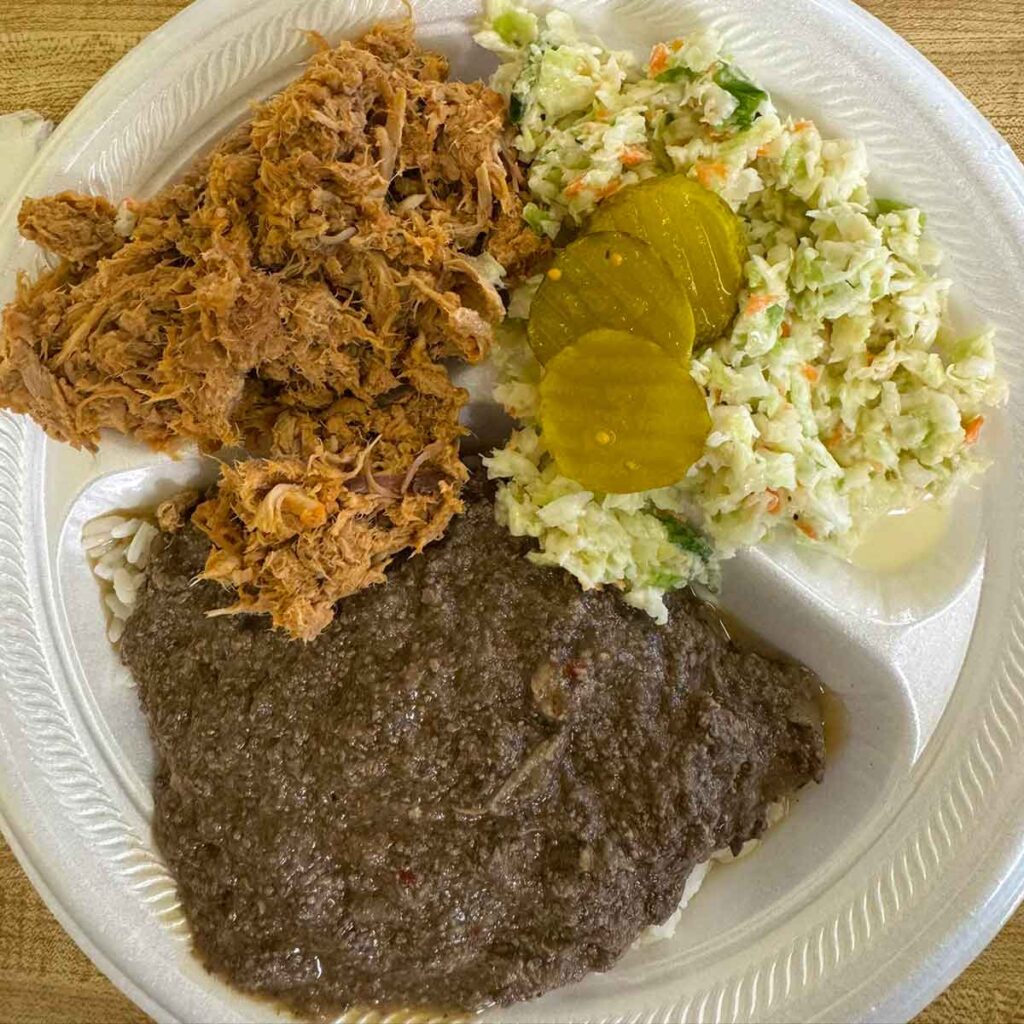 BBQ plate from Country Cousins in Olanta, SC, showing pork barbecue, liver hash over rice, with slaw and pickles.