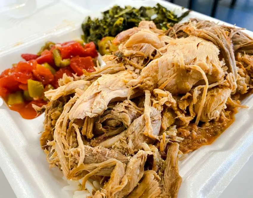 BBQ plate with stewed tomatoes, greens, and pulled pork over hash and rice from McCabe's in Manning.