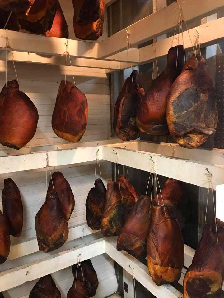 Country hams hanging in closet at Cooper's.
