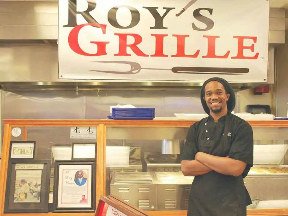 Chris Williams standing in front of his order station at Roy's Grille.
