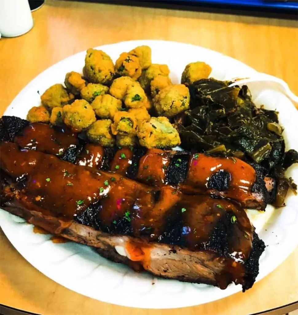 Ribs, okra, and collards on white styrofoam plate.