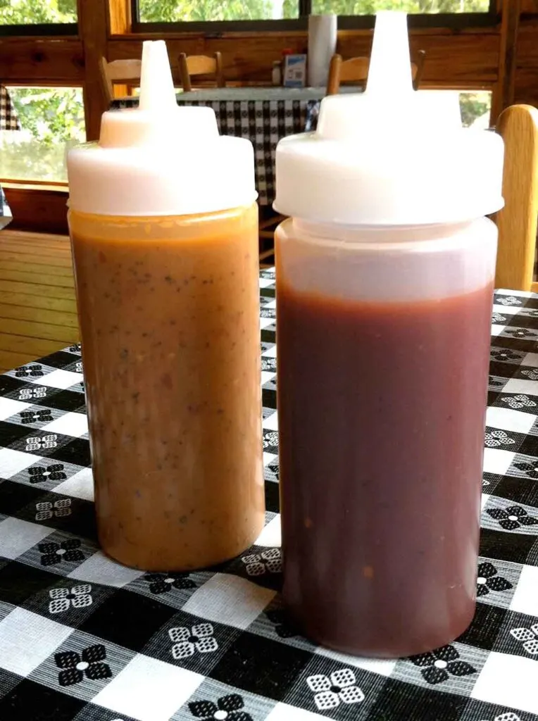 Two bottles of Shuler's Barbecue sauce, one mustard and one vinegar based.