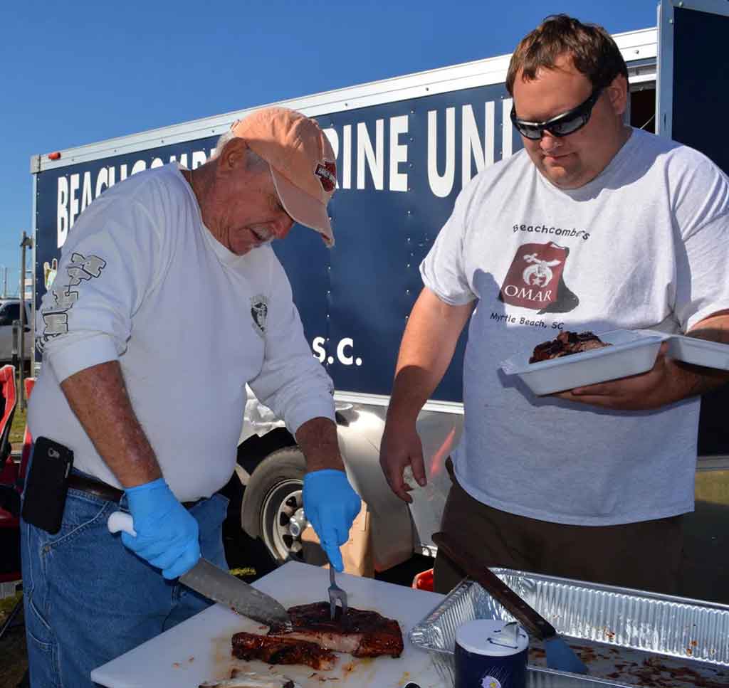 Pair of competitors at Smoke on the Beach cut ribs to turn in.