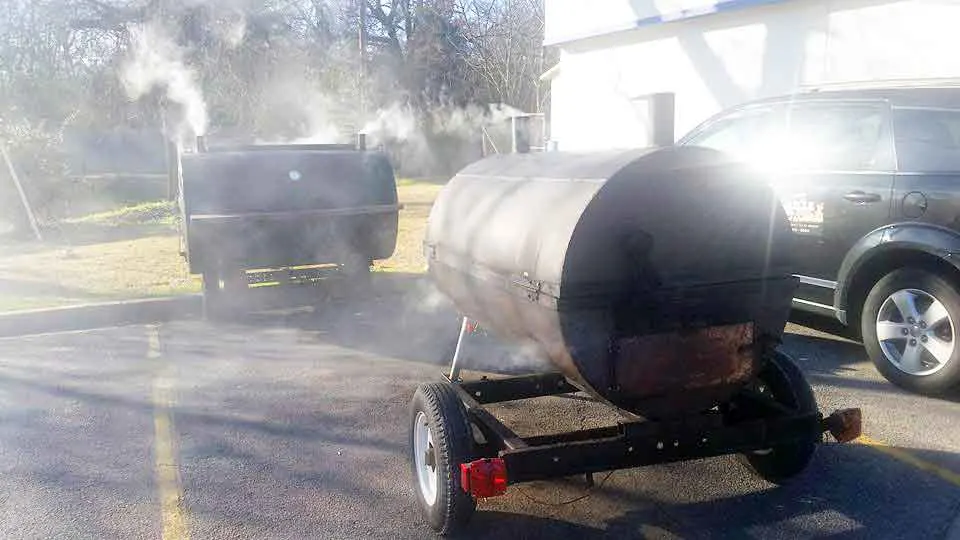 Two smokers and lots of smoke outside of Roy's.