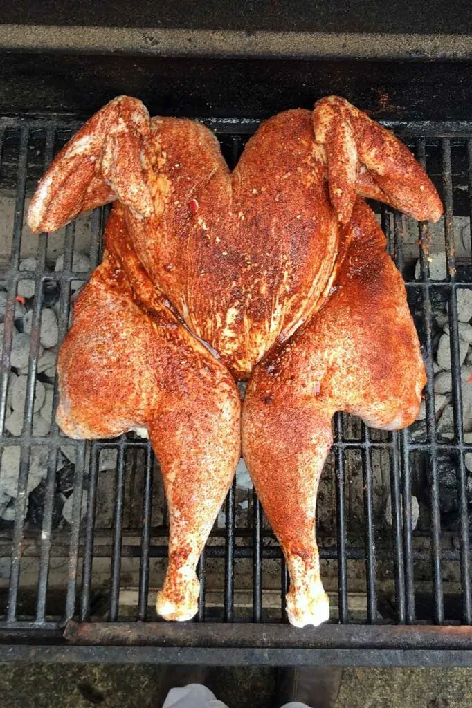 Spatchcocked turkey with dry rub on grill with indirect heat