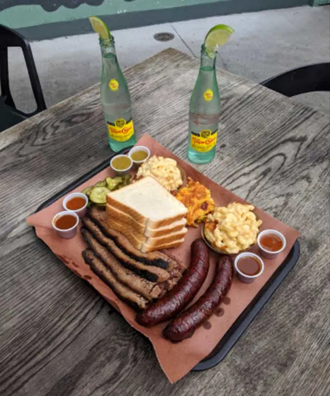 Brisket and Hot Guts Sausage with Mac n cheese, corn pudding, pickles and sauces.