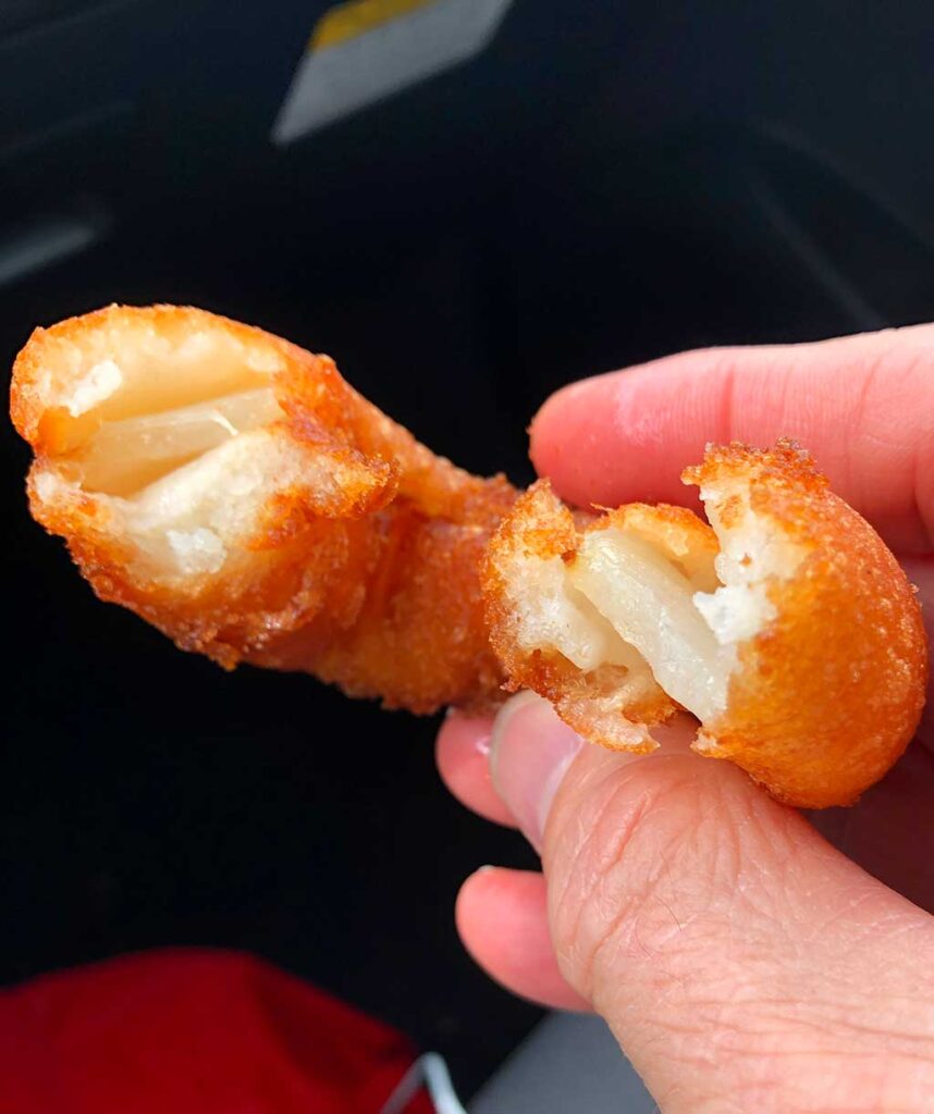 Onion ring from Bessinger's BBQ bitten in half with interior showing