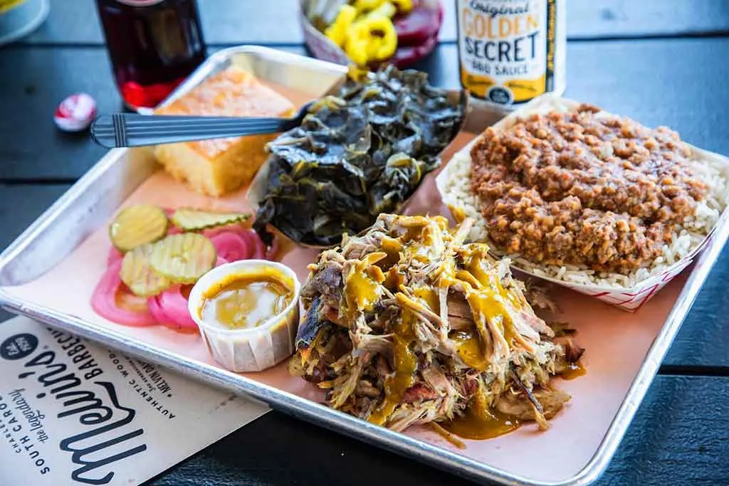 Pulled pork with hash and rice, collards and cornbread on tray from Melvin’s Bar-B-Que.
