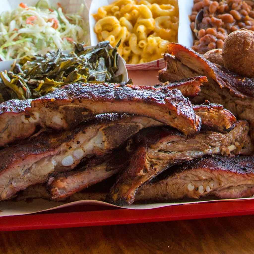 Ribs from Rodney Scott with several sides in the background.