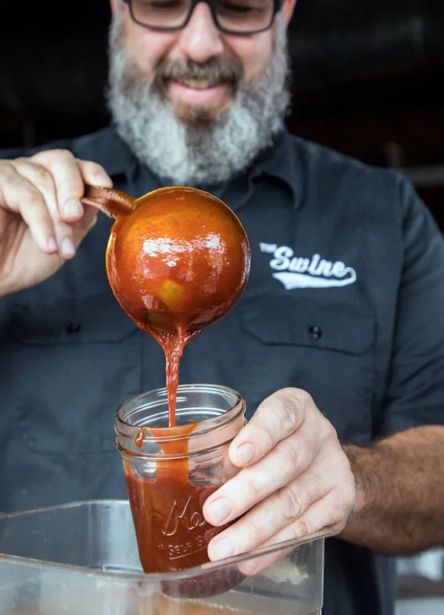 Anthony DiBernardo pouring sauce into jar