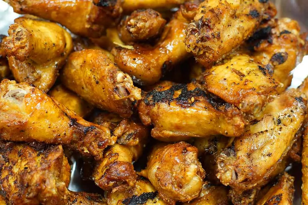 Closeup of yellow, cooked chicken wings