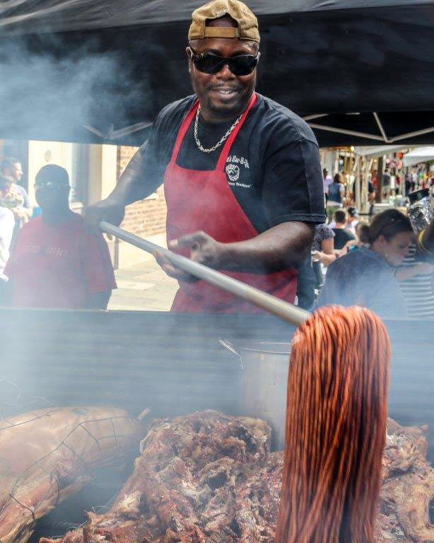 Rodney Scott mopping whole hogs on pit for barbecue