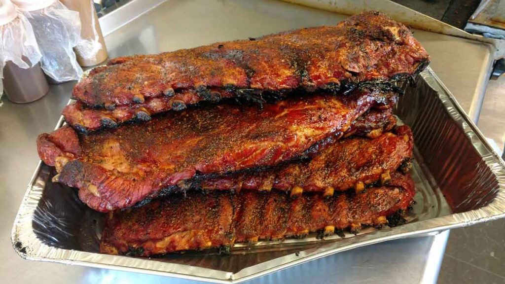 Several slabs of spareribs in an aluminum tray.