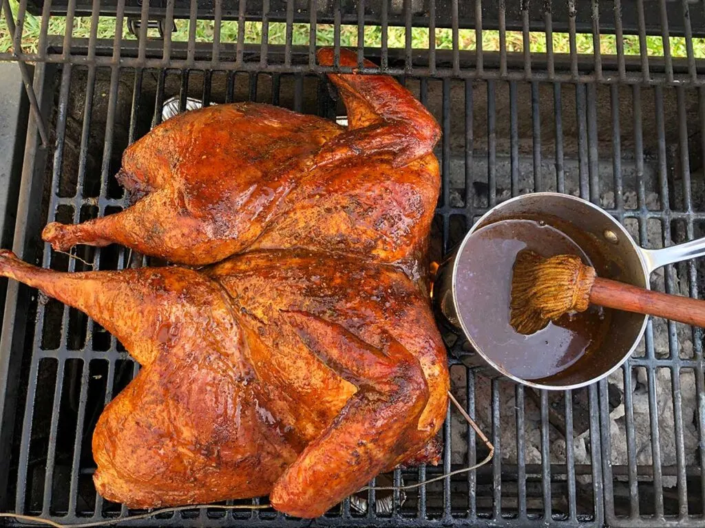 Rodney Scott's smoked spatchcocked turkey on grill with his mop sauce.
