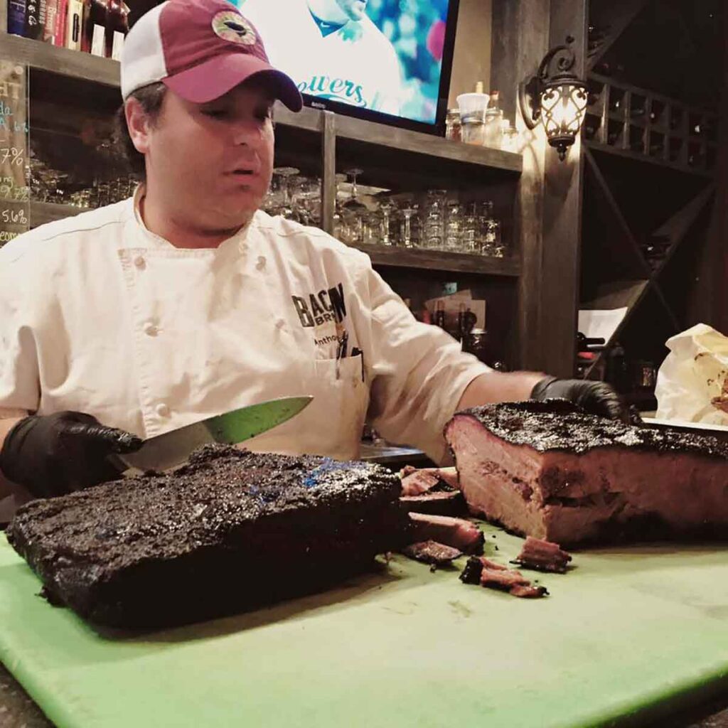 Chef Gray looking at a sliced brisket