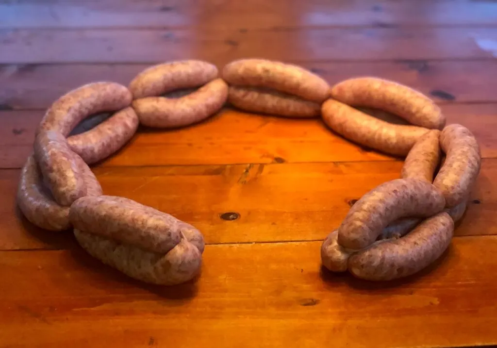 Circle of onion sausage links on wooden table