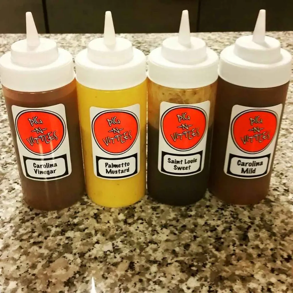 Four bottles of BBQ sauce on table